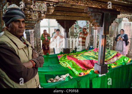 Fatehpur Sikri, Mausoleo di Sheikh Salim Chishti. Custode sulla sinistra, offerta monetaria di fronte. Foto Stock