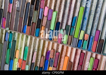 Close-up, angolate verso il basso vista della scatola grande di usato, color pastello artista chalks giacente in righe verticali. Foto Stock