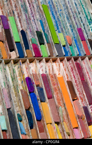 Close-up, angolo di visualizzazione della casella di grandi dimensioni di usato, color pastello artista chalks giacente in righe verticali. Orientamento verticale. Foto Stock