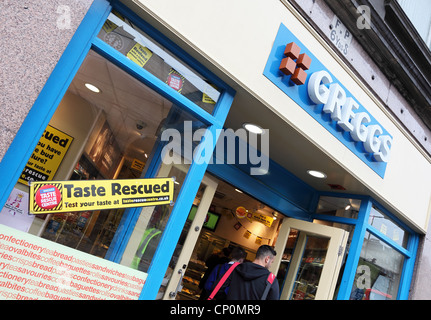 Giovane uomo entrare Greggs fornai shop a Newcastle upon Tyne, England, Regno Unito Foto Stock