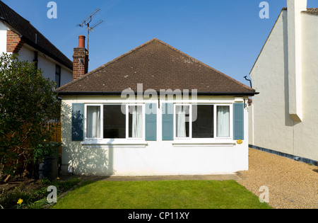 Piccole / compact bungalow home con perfetta erba verde prato e un cielo blu, in Molesey / Walton on Thames, Surrey. Regno Unito Foto Stock