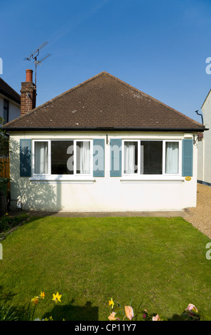 Piccole / compact bungalow home con perfetta erba verde prato e un cielo blu, in Molesey / Walton on Thames, Surrey. Regno Unito Foto Stock