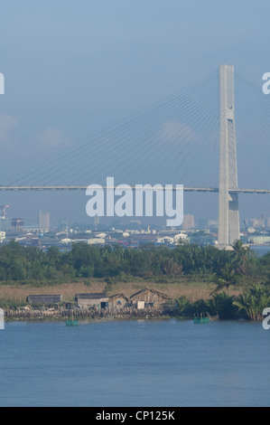 Il Vietnam, Ho chi minh city (aka saigon). vedute lungo il fiume Saigon. tipica vista fiume con saigon skyline della città in distanza. Foto Stock