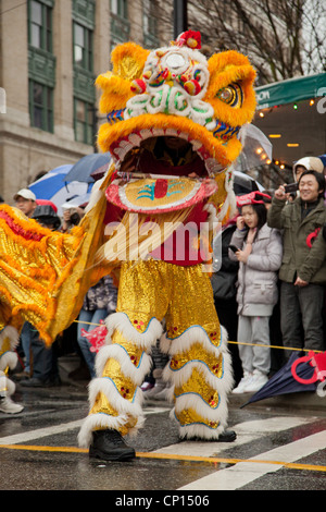 Nella bocca di un cinese tradizionale danza del leone per le strade di Vancouver China Town. Foto Stock