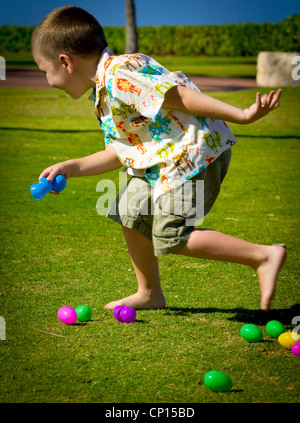 A quattro anni ragazzo autistico chiacchiere a causa di tutte le emozioni durante il gioco con le uova di Pasqua. Foto Stock