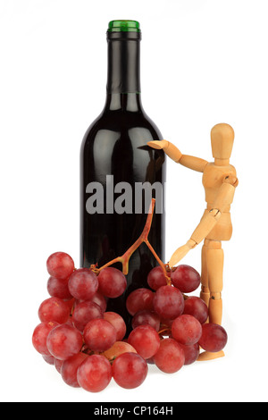 Legno Puppet sorge accanto ad una bottiglia di vino con uve Foto Stock