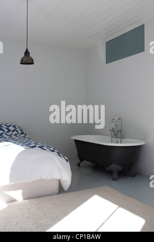 Freestanding vasca da bagno in camera da letto, Princelet Street, Londra, Regno Unito. Chris Dyson architetti. Foto Stock
