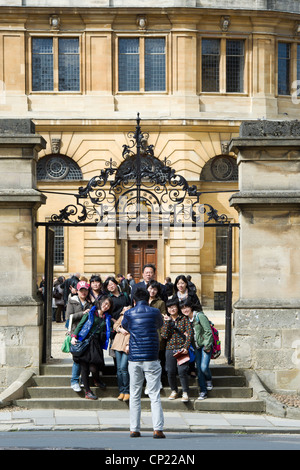 I turisti giapponesi avente vi foto scattata al di fuori Sheldonian Theatre, Oxford, Oxfordshire, Inghilterra Foto Stock