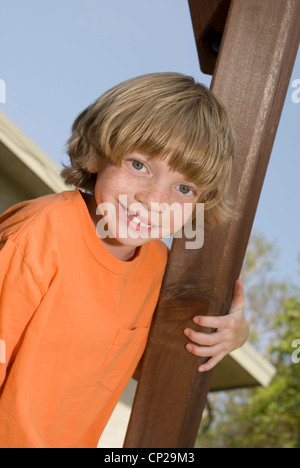 Carino kid salendo su un outdoor playset. Foto Stock