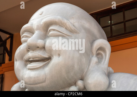 Scultura in pietra di un felice Buddha Sorridente, Danang, Vietnam Foto Stock