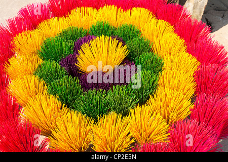 Fasci colorati di bastoncini di incenso in vendita, disposti come un fiore, Xuan Thuy Hat Village, vicino a tonalità, Vietnam Foto Stock