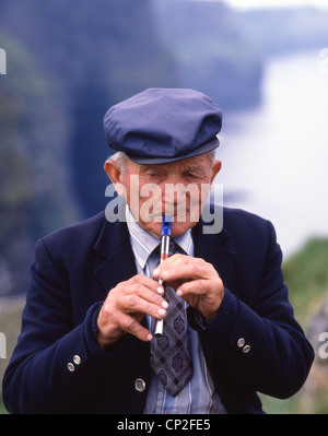 Uomo locale giocando Irish whistle (feadóg stáin), nella contea di Cork, Repubblica di Irlanda Foto Stock