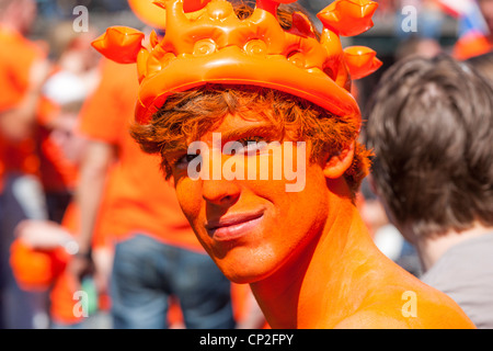 Amsterdam ritratto di un felice giovane con faccia arancione vernice su Kingsday Kings giorno. Paesi Bassi Olanda Foto Stock