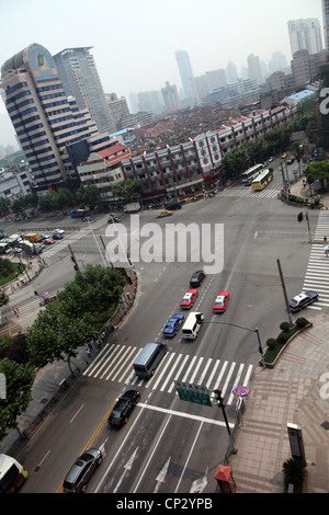 E' un bivio in Shanghai. Siamo in grado di vedere alcune automobili in attesa al semaforo ans alcune tipiche case in background. Foto Stock