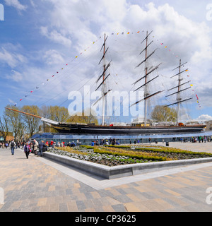 Persone nello spazio aperto lastricato presso lo storico tè Cutty Sark nave museo clipper e aperto ai visitatori a bordo dopo il restauro Greenwich Londra Inghilterra Regno Unito Foto Stock