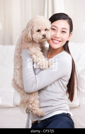 Giovane donna giocando con un pet barboncino Toy Foto Stock