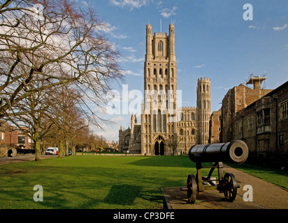 La West Tower e ingresso alla Cattedrale di Ely Cambridgeshire Inghilterra con il cannone russo sul verde del palazzo Foto Stock