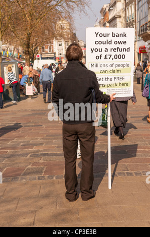 Un uomo con un segno di raccontare delle possibili restituzioni banca in Norwich , Norfolk , Inghilterra , Inghilterra , Regno Unito Foto Stock