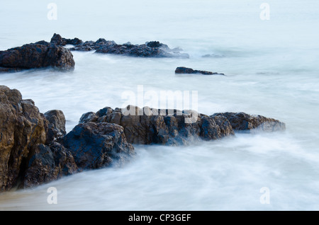 Le onde del mare linea gioco rock di impatto sulla spiaggia Foto Stock