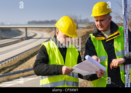 Geometri su autostrada geodesist lettura piani utilizzano tacheometer Foto Stock