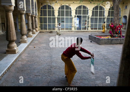 Ragazzi giocare a cricket all'interno di uno degli edifici della Surya Mandir (noto come il tempio delle scimmie), Jaipur, India Foto Stock