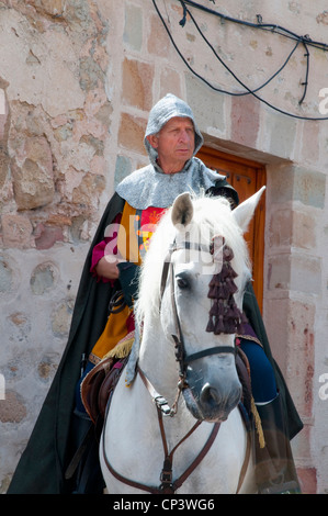 Uomo che indossa abiti medievali, a cavallo. Sigüenza, provincia di Guadalajara, Castilla La Mancha, in Spagna. Foto Stock