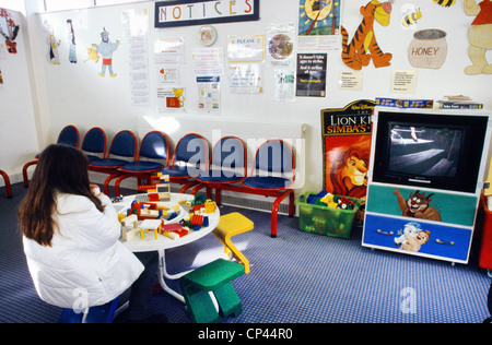 Nhs Hospital - bambini ala sala attesa bambino guardando film Foto Stock