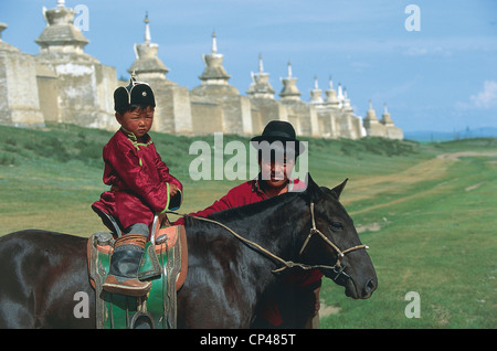 Mongolia - Regione Khudjirt - Erdeni-Zuu, il monastero del XVI secolo. In primo piano, un giovane con un bambino a cavallo. Foto Stock