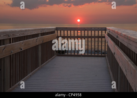 Il sole è appena sopra l'orizzonte oltre l'oceano atlantico in prima mattinata a un pubblico accesso alla spiaggia in Nag Testa, Carolina del Nord Foto Stock