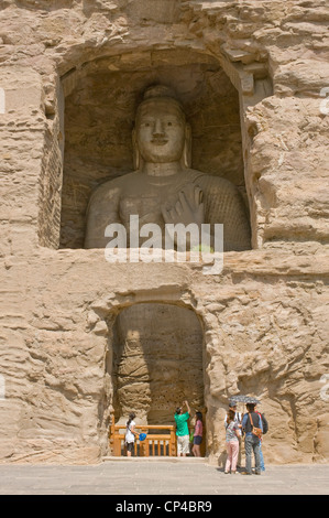 I turisti che visitano il Buddha bianco (Grotta n. 20) presso le grotte di Yungang. Foto Stock