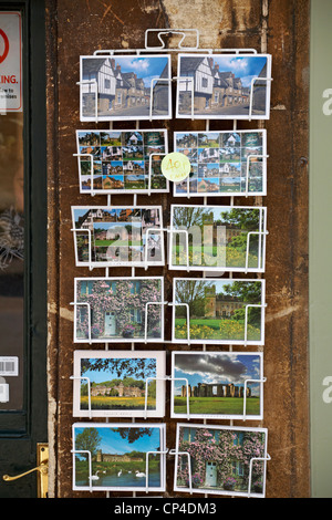 Cartoline di Lacock e Stonehenge in rack per la vendita fuori negozio a Lacock, Wiltshire, Regno Unito nel mese di aprile Foto Stock