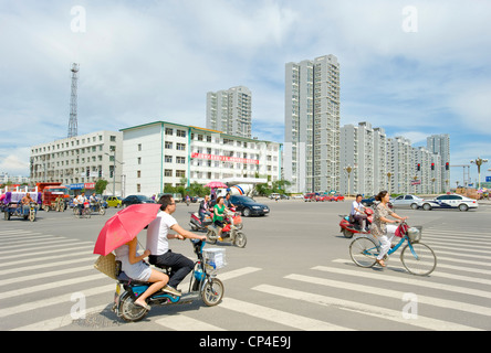 Una giunzione occupato lungo una delle strade principali di Datong con moderni blocchi di appartamenti in background. Foto Stock