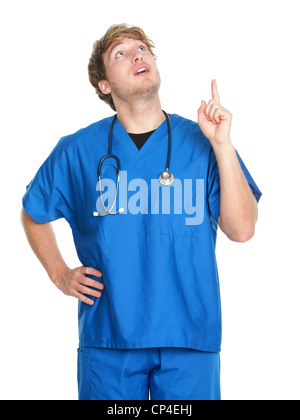 Giovane maschio caucasico infermiere medico in blu frega di puntamento e cercando in piedi isolato su sfondo bianco Foto Stock