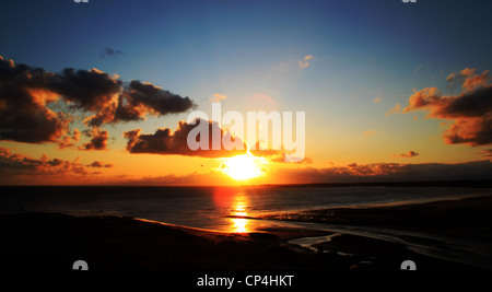 Tramonto con drammatica nuvole nel cielo a Ogmore dal mare a sud Wales coast Foto Stock