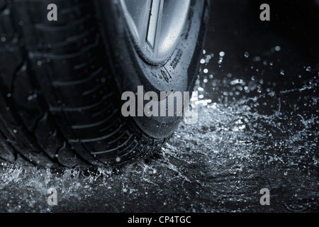 Pneumatico auto schizzi in acqua. Foto Stock