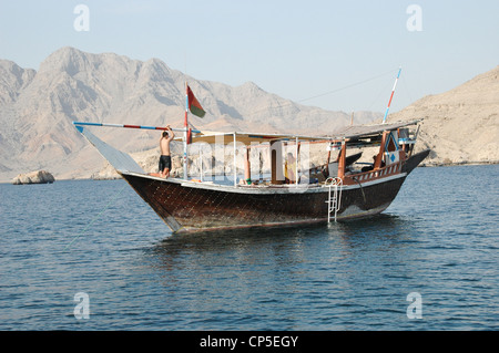 Un dhow che trasporta passeggeri nei fiordi della Penisola di Musandam, appena sotto lo stretto di Hormuz, nel Sultanato di Oman. Foto Stock