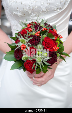 Sposa tenendo un mazzo di rose al suo matrimonio Foto Stock