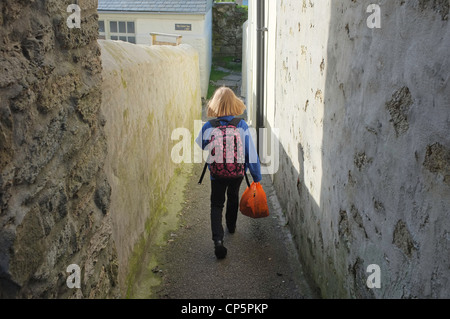 Un 9 anno vecchia ragazza cammina a scuola nel lavaggio, Cornwall, Regno Unito Foto Stock