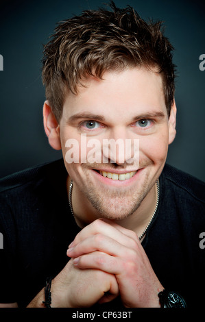 Guardando bene, uomo sorridente in ritratti, le sue mani sono piegati, Foto Stock