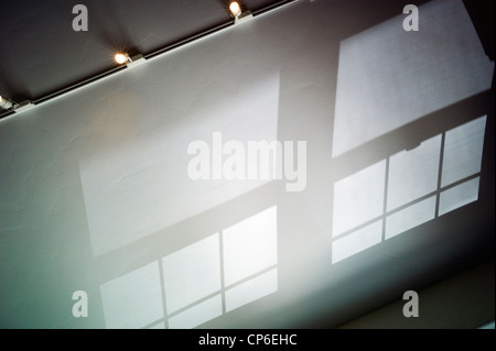 Riflessi e ombre e modelli di vetro colato sul soffitto a volta di un ufficio a casa. Foto Stock