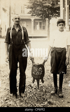 Padre e Figlio tenendo premuto fino 30 Pound Turtle Foto Stock