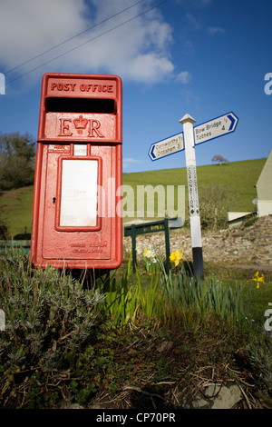 Tradizionale in rosso postbox in scena rurale e firmare post, Devon, Inghilterra. Foto Stock