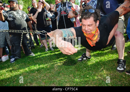 Un uomo giocando rimorchiatore di guerra con ganci nel suo avambraccio. A NYC Zombie Crawl, 30 maggio 2010. New York City, NY, STATI UNITI D'AMERICA. Foto Stock