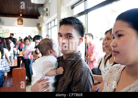 Città Lapu-Lapu, Filippine, 26/02/2012: 200-300 bambini battezzati in un solo 3 ore di cerimonia alla Mactan Air Base cappella. Foto Stock