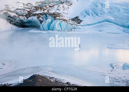 Donna pattinaggio sul ghiaccio di fronte del ghiacciaio di borsette, Chugach Mountains vicino a Cordova, centromeridionale Alaska, inverno Foto Stock