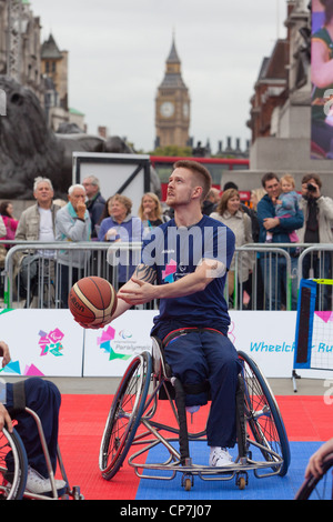 Concorrente giocare a basket durante International Paralympic Day 2011, Trafalgar Square, Londra, Big Ben in background, Foto Stock