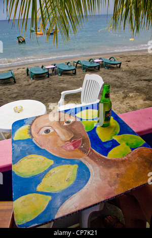 Tavola dipinta con una donna stilizzata e limoni in una caffetteria sulla spiaggia in mero Western Dominica nel West Indies Foto Stock