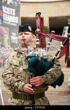 Piper da le guardie scozzesi suonando a un esercito il reclutamento di stare nel centro della città di Glasgow Scotland Regno Unito Foto Stock