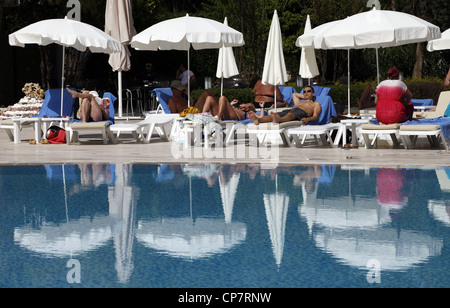 Ombrelloni BIANCHI & riflessioni a lato piscina Turchia 15 Aprile 2012 Foto Stock