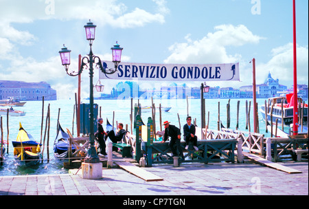 Immagine di una stazione Gondola 'Servizio Gondole' sulla San Marco Canal Grande con gondolieri in attesa per i clienti a Venezia, Italia Foto Stock